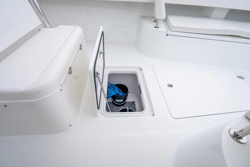 Slide: The Image of 2017 Bahama Center Console boat storage compartment with open hatch and bucket inside. - 9