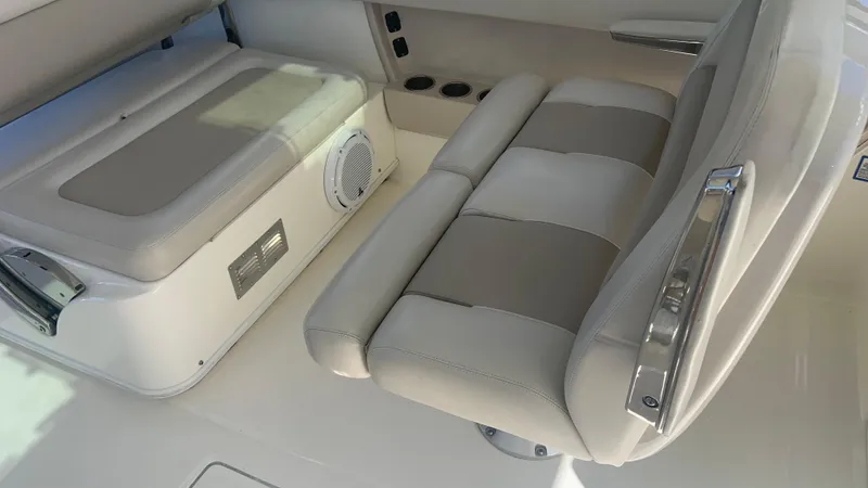 Slide: The Image of 2019 Boston Whaler 320 Vantage interior seating with storage and cup holders. - 11