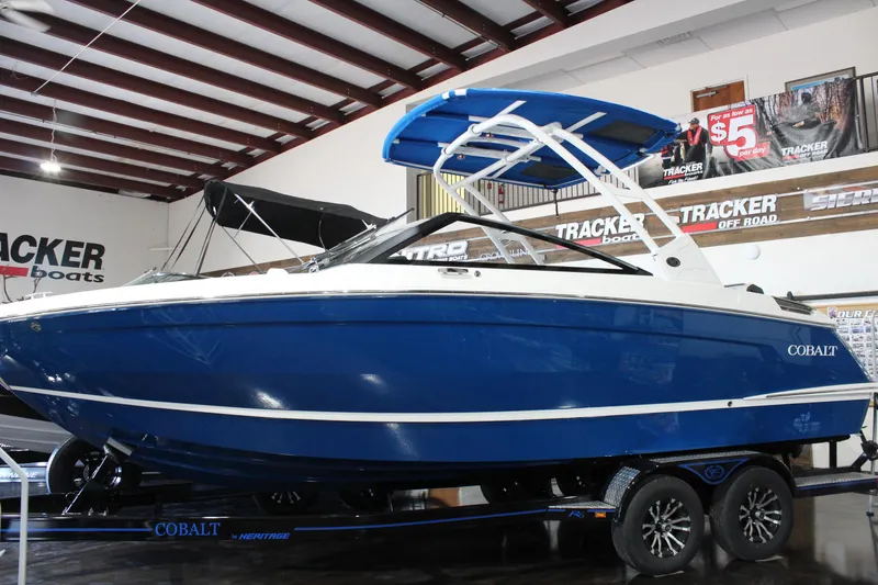 The Image of 2025 Cobalt R6 boat in showroom, blue and white design, on trailer. - 0