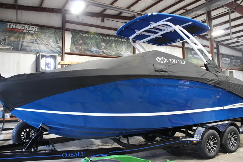 Slide: The Image of 2025 Cobalt R6 boat in showroom, blue hull, black cover, on trailer. - 10