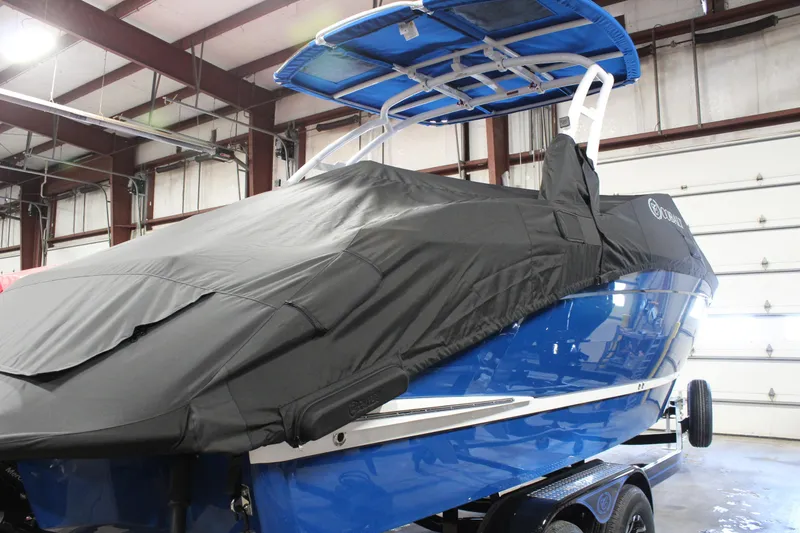 Slide: The Image of 2025 Cobalt R6 boat covered in a garage, featuring a blue hull and black cover. - 11