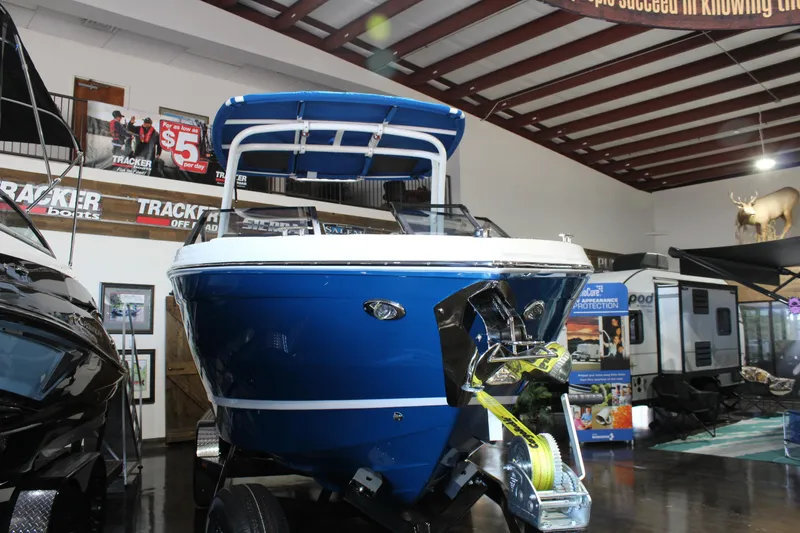 Slide: The Image of 2025 Cobalt R6 boat displayed indoors, featuring a sleek blue design. - 2