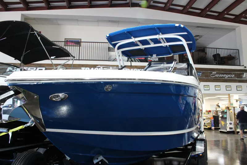 Slide: The Image of 2025 Cobalt R6 boat with blue hull and canopy displayed indoors. - 4