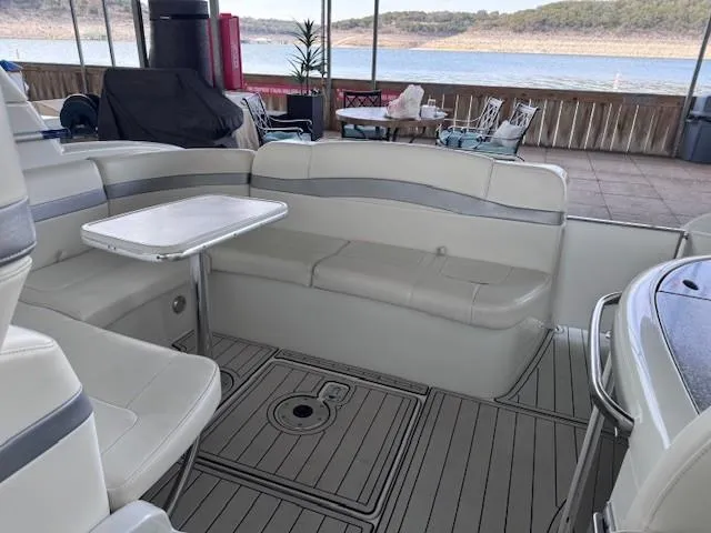 Slide: The Image of 2006 Formula 34 PC boat interior with seating and table, docked by a scenic lake. - 15