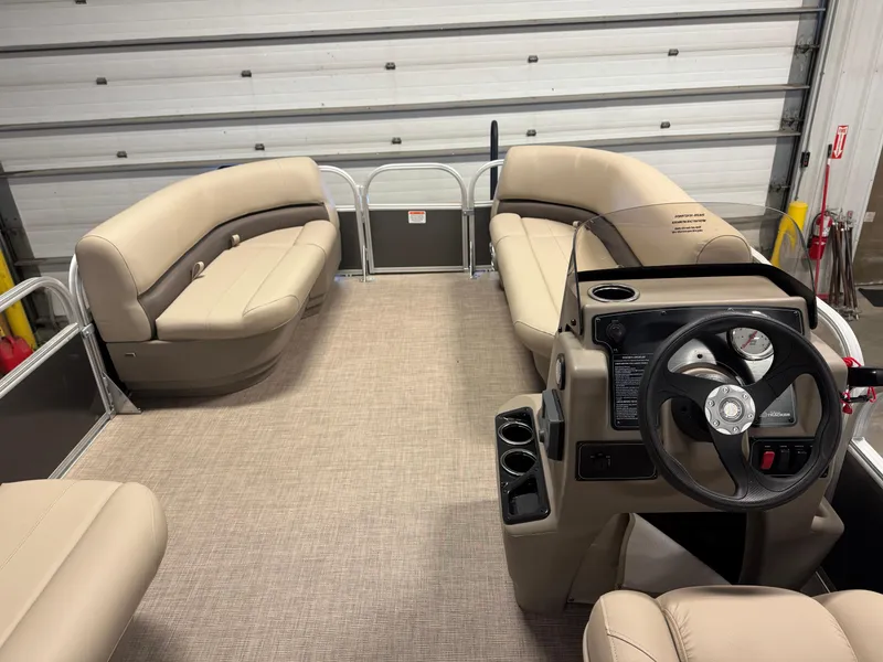 Slide: The Image of 2025 Sun Tracker Party Barge 16 DLX interior with beige seating and steering console. - 11