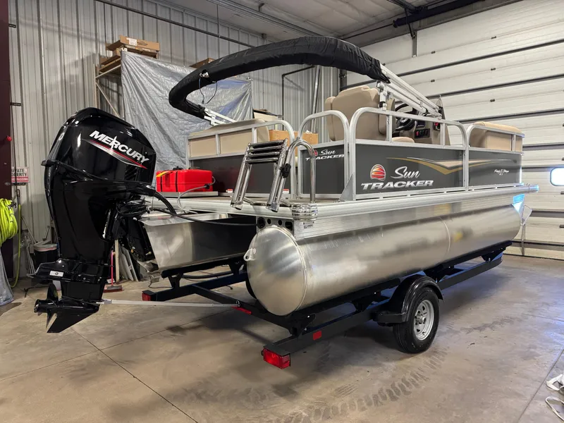 Slide: The Image of 2025 Sun Tracker Party Barge 16 DLX pontoon boat in a garage setting. - 3