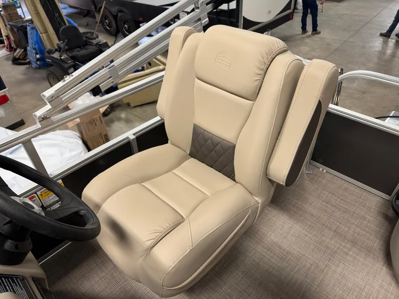 Slide: The Image of 2025 Sun Tracker Party Barge 16 DLX captain's chair, beige upholstery, indoor showroom. - 5