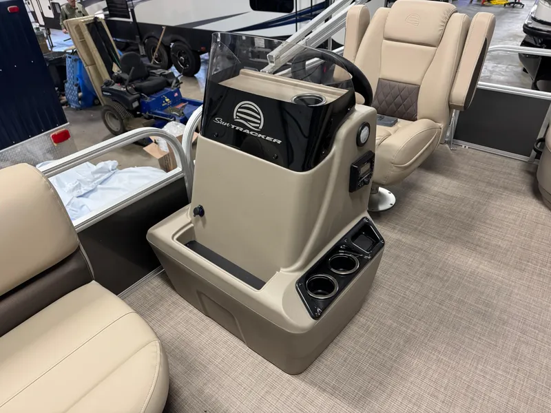 Slide: The Image of 2025 Sun Tracker Party Barge 16 DLX interior with beige seating and control console. - 7
