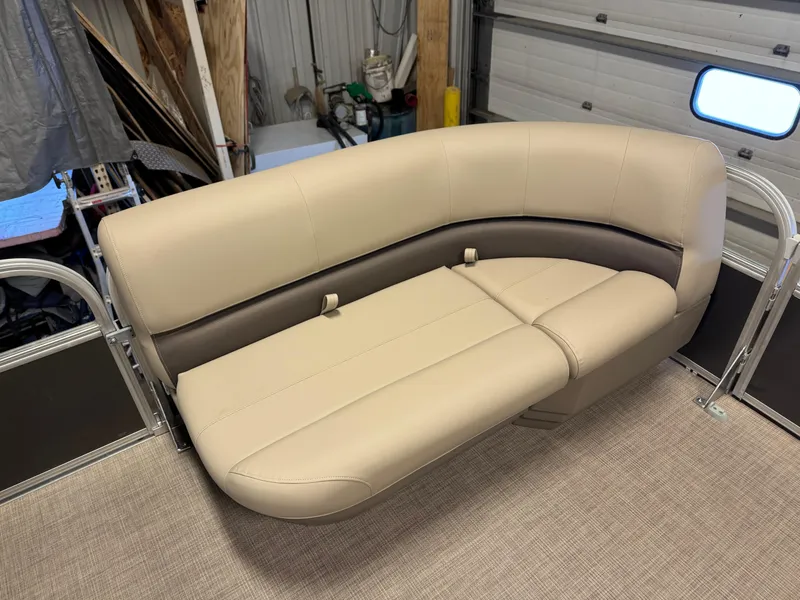 Slide: The Image of 2025 Sun Tracker Party Barge 16 DLX beige seating in a garage setting. - 9