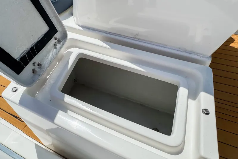 Slide: The Image of Open storage compartment on 2023 Northstar Axis 4.8 boat, featuring sleek white design. - 10