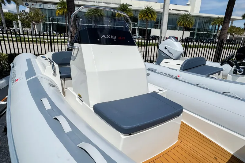 Slide: The Image of 2023 Northstar Axis 4.8 boat with sleek design and modern features, docked outdoors. - 11