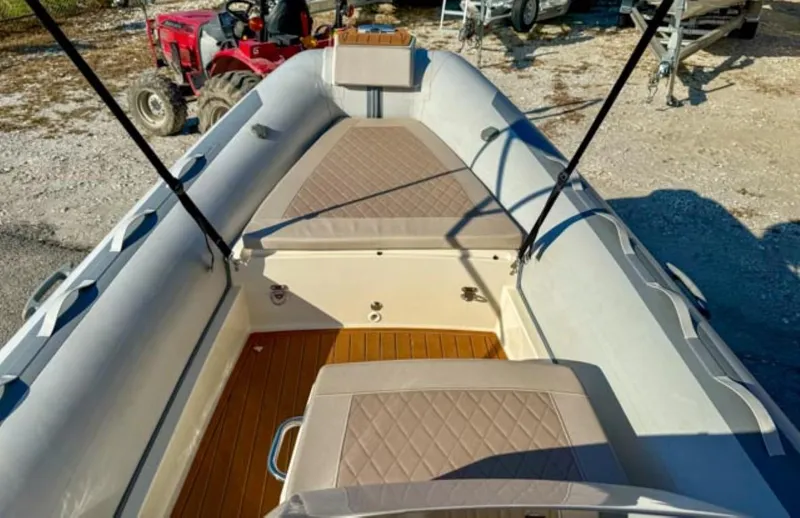Slide: The Image of 2023 Northstar Axis 4.8 RIB boat interior with cushioned seating and wooden flooring. - 4