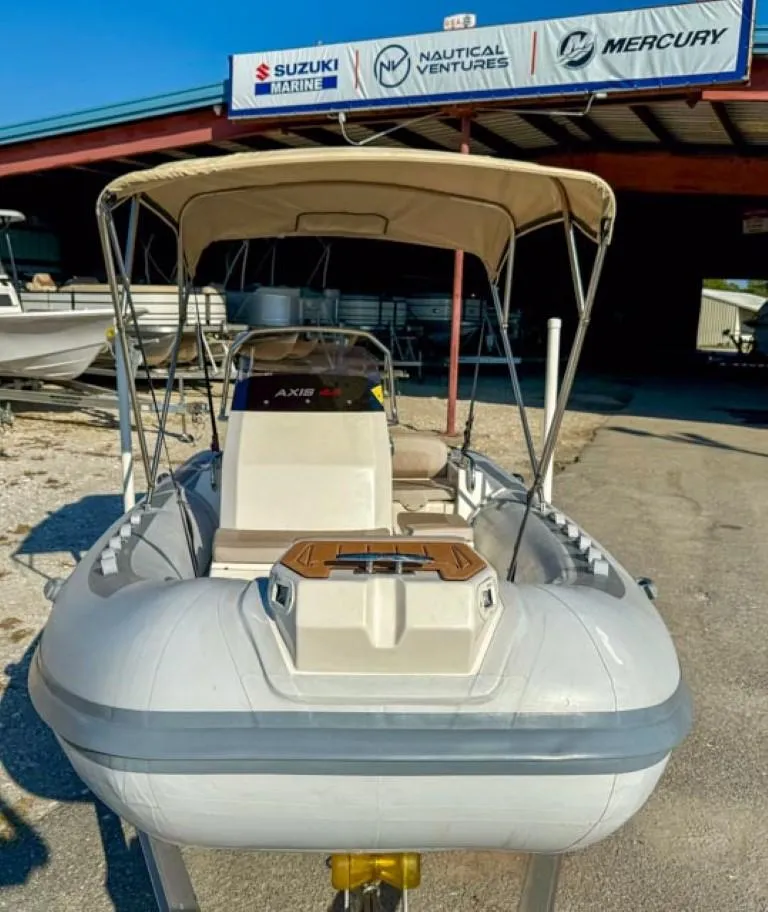 Slide: The Image of 2023 Northstar Axis 4.8 RIB boat with canopy, displayed outdoors. - 7