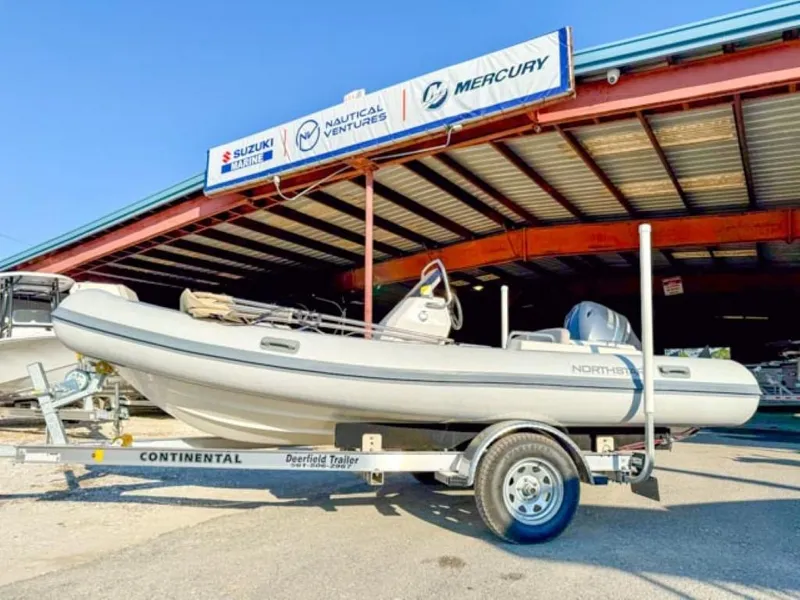 The Image of 2023 Northstar Axis 4.8 RIB boat on trailer outside dealership. - 0