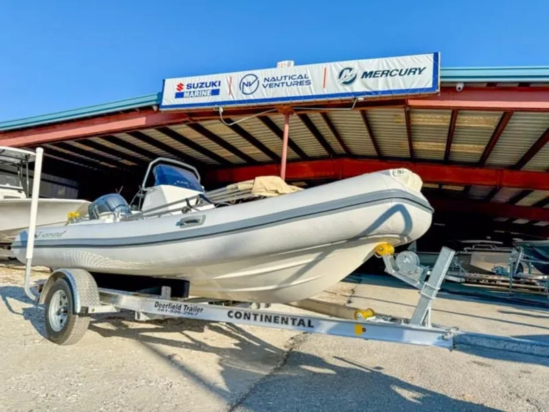 Slide: The Image of 2023 Northstar Axis 4.8 RIB boat on trailer, displayed at a dealership. - 2