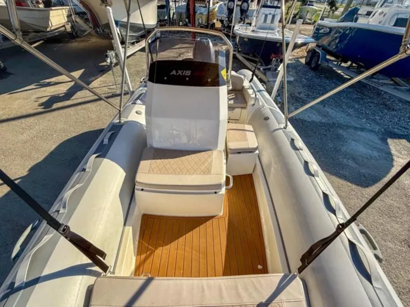 Slide: The Image of 2023 Northstar Axis 4.8 RIB boat with cushioned seating and wooden deck. - 5