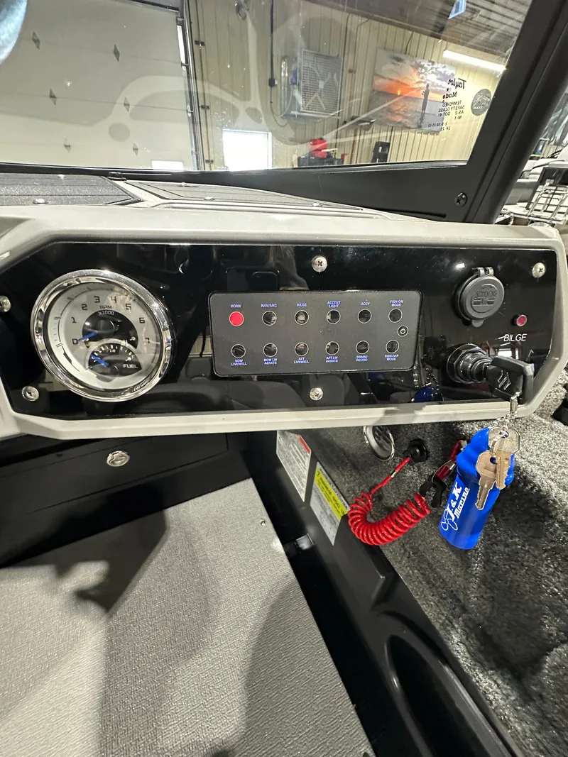 Slide: The Image of 2025 Smoker Craft Adventurer 188 DC dashboard with control panel and ignition keys. - 4
