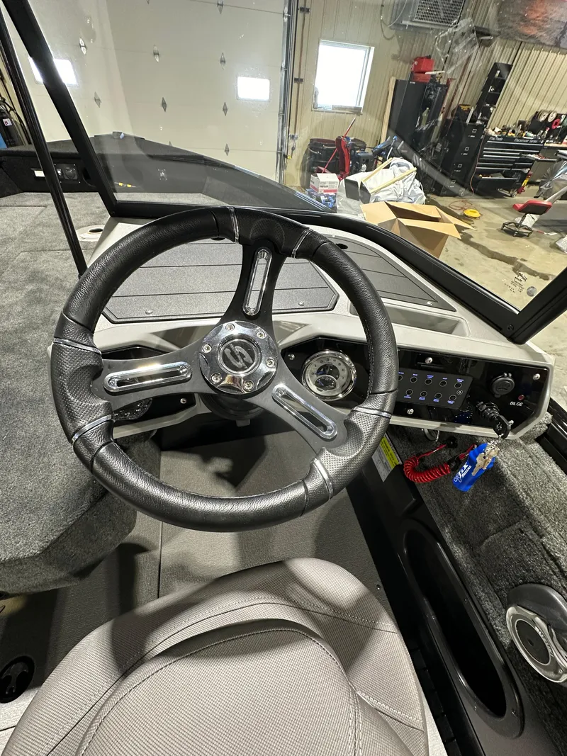 Slide: The Image of 2025 Smoker Craft Adventurer 188 DC boat interior, featuring steering wheel and dashboard controls. - 5