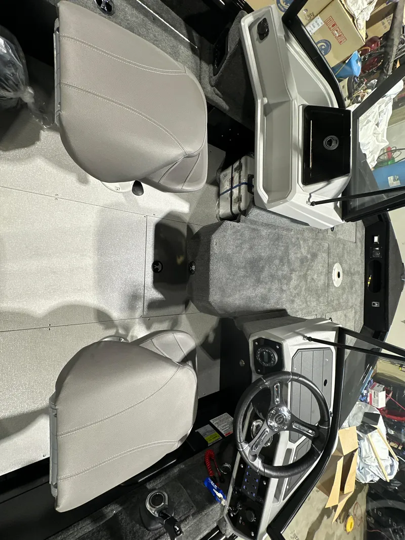 Slide: The Image of 2025 Smoker Craft Adventurer 188 DC boat interior with steering wheel and seating. - 6