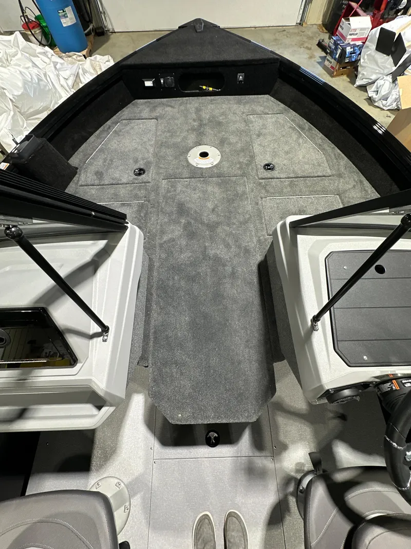 Slide: The Image of 2025 Smoker Craft Adventurer 188 DC boat interior with gray carpet and seating. - 7