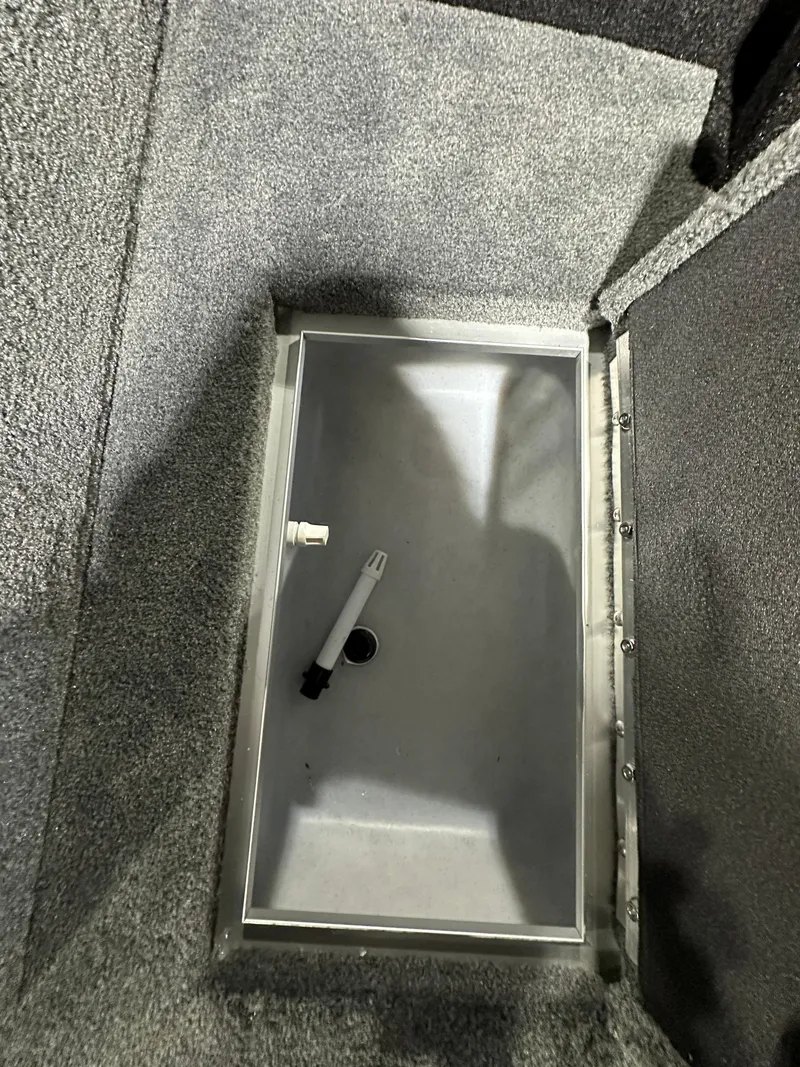 Slide: The Image of Storage compartment in 2025 Smoker Craft Adventurer 188 DC boat, featuring a secure latch. - 9