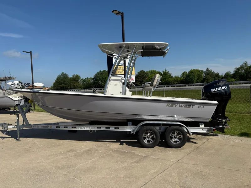 Slide: The Image of 2025 Key West 230 Bay Reef boat on trailer, featuring Suzuki outboard motor. - 1
