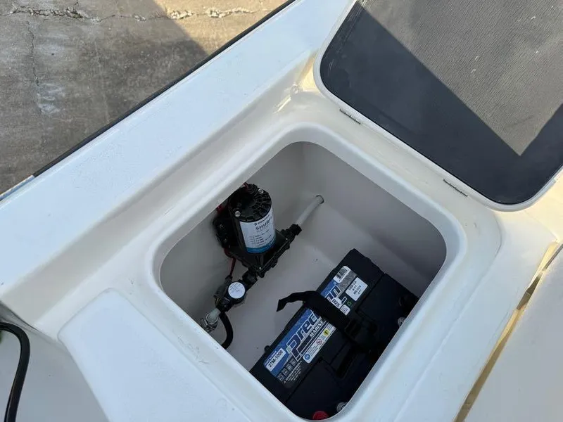 Slide: The Image of 2025 Key West 230 Bay Reef boat compartment with battery and pump. - 12