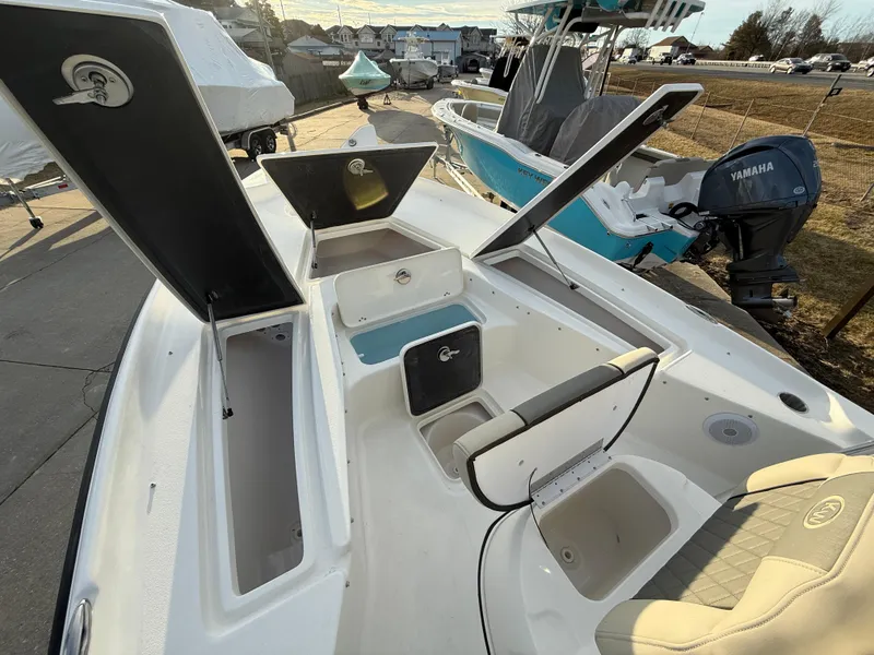 Slide: The Image of 2025 Key West 230 Bay Reef boat with open storage compartments and Yamaha engine. - 23