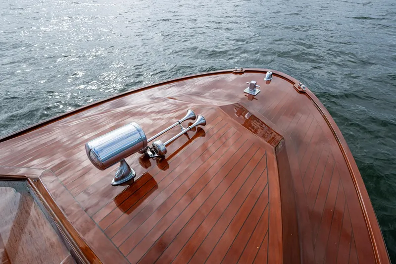 Slide: The Image of 2010 Blackfin 28 CC boat with polished wooden deck on water. - 11