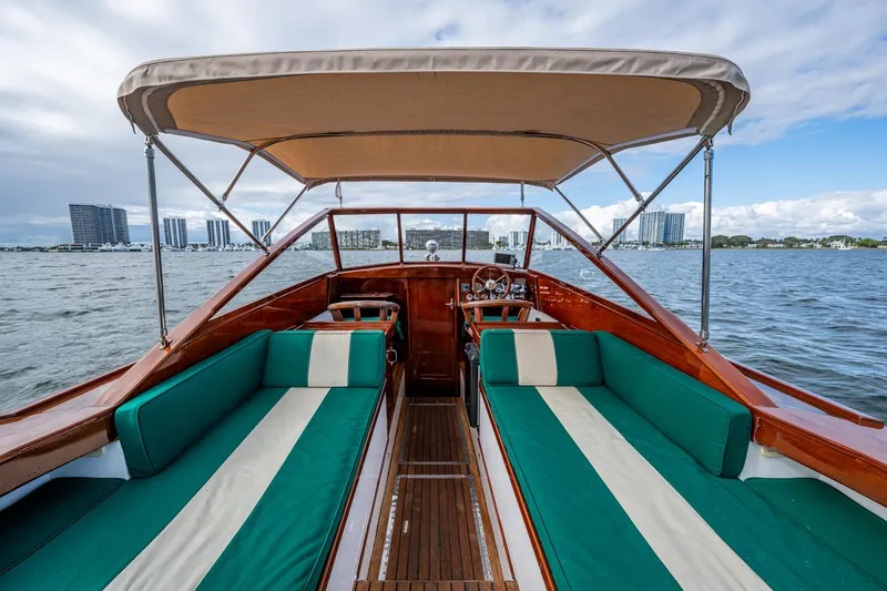 Slide: The Image of 2010 Blackfin 28 CC boat interior with green seating, canopy, and waterfront view. - 3