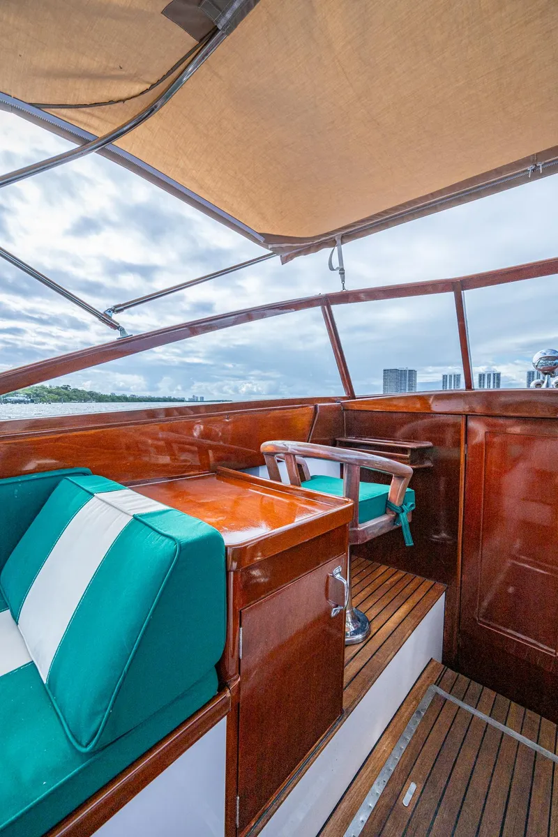 Slide: The Image of 2010 Blackfin 28 CC boat interior with teal and white seating, wooden accents, and canopy. - 6