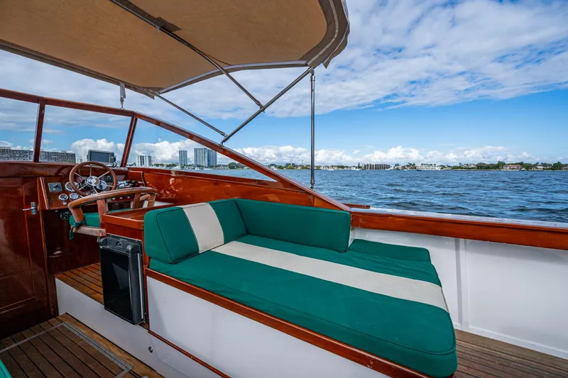 Slide: The Image of 2010 Blackfin 28 CC boat with green seating, wooden accents, and canopy on a sunny day. - 9