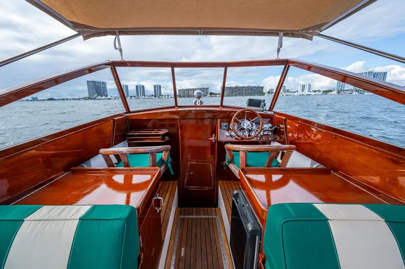 Slide: The Image of Interior view of 2010 Blackfin 28 CC boat with polished wood and green seating. - 7