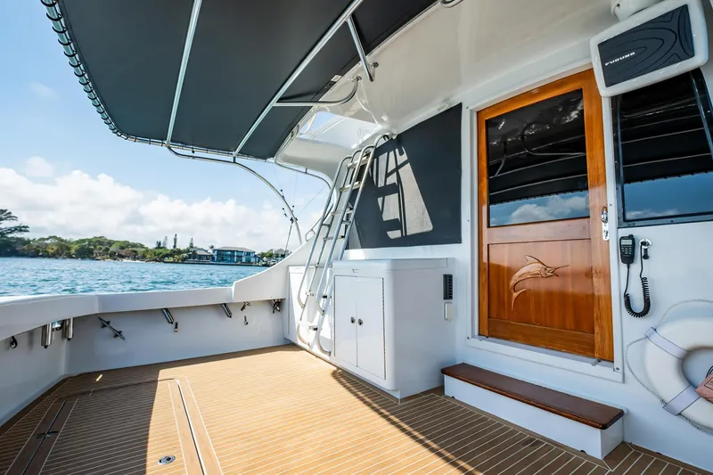 Slide: The Image of 1991 Jersey 42 Convertible Sportfisherman boat deck with wooden flooring and scenic water view. - 18