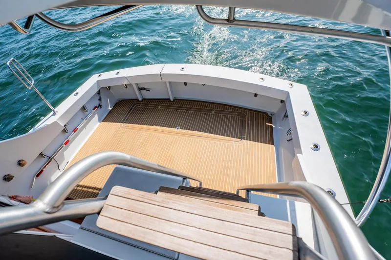 Slide: The Image of 1991 Jersey 42 Convertible Sportfisherman boat deck with wooden flooring and ocean view. - 23