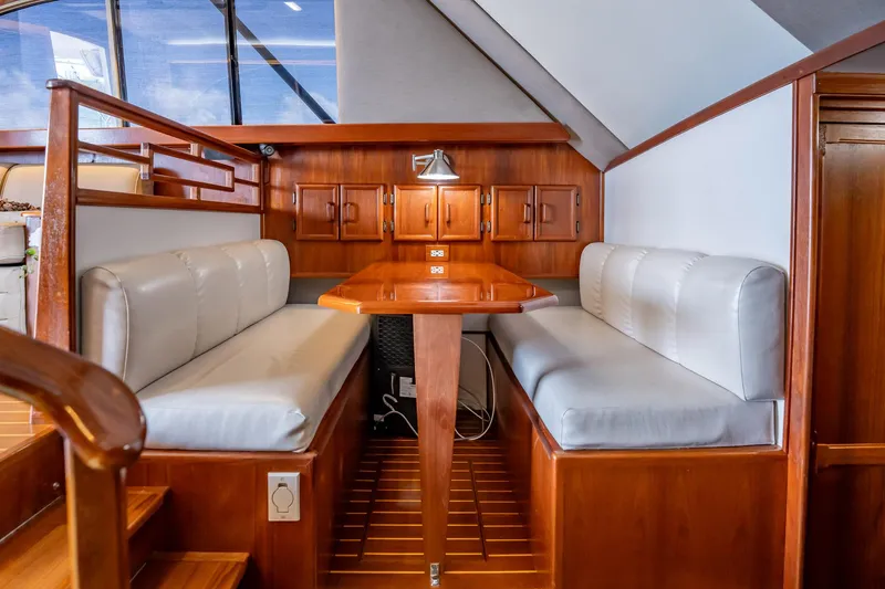 Slide: The Image of Interior of 1991 Jersey 42 Convertible Sportfisherman with wooden dining area and cushioned seating. - 28