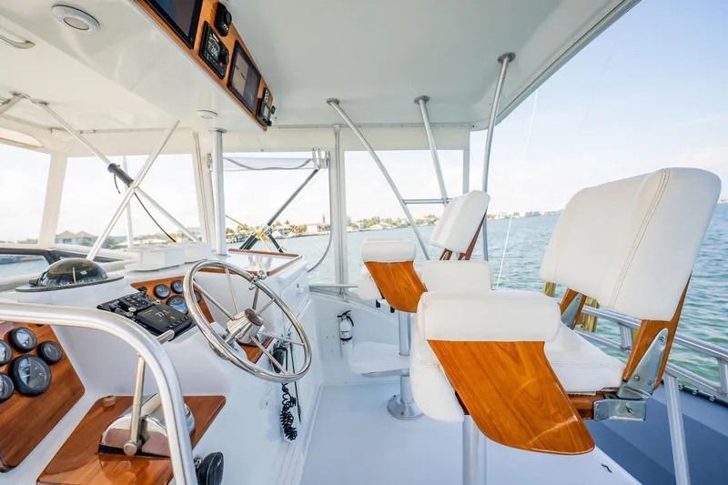 Slide: The Image of 1991 Jersey 42 Convertible Sportfisherman helm with wooden accents and ocean view. - 29