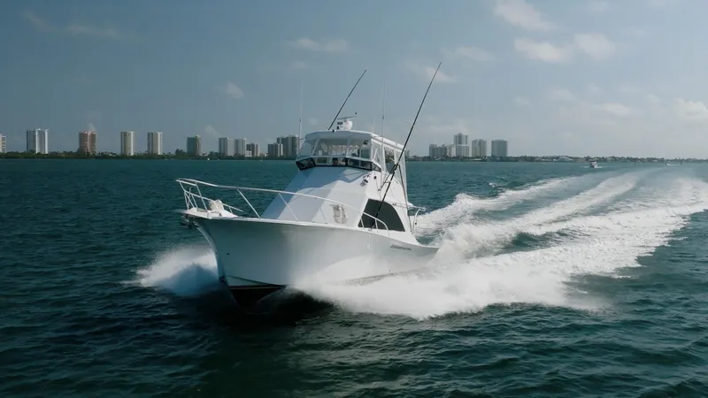 Slide: The Image of 1991 Jersey 42 Convertible Sportfisherman cruising on open water, city skyline in background. - 5