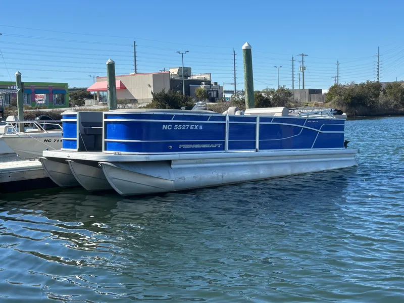 Slide: The Image of 2022 Princecraft Vectra 23 pontoon boat docked on calm water. - 0