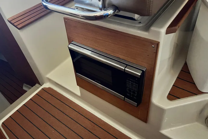 Slide: The Image of 2020 Ranger Tugs 27 interior with built-in microwave and wood accents. - 15