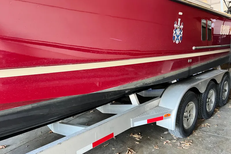 Slide: The Image of Red 2020 Ranger Tugs 27 boat on a triple-axle trailer in a garage. - 2