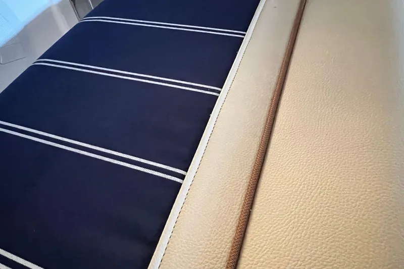 Slide: The Image of Ranger Tugs 27 interior seating, 2020 model, featuring striped and beige upholstery. - 6