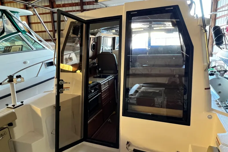 Slide: The Image of 2020 Ranger Tugs 27 boat interior with open door, showcasing cabin and seating area. - 7