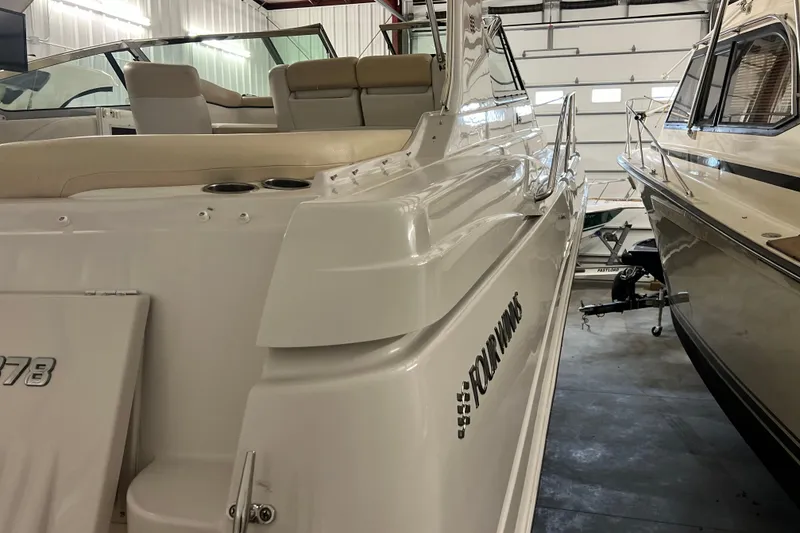 Slide: The Image of 2008 Four Winns V378 boat in storage, showcasing sleek design and white exterior. - 18