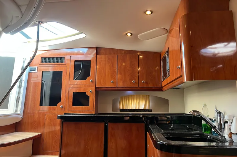 Slide: The Image of Luxurious 2008 Four Winns V378 yacht interior with wood cabinetry and modern kitchen amenities. - 22