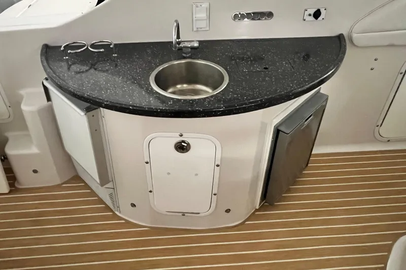 Slide: The Image of 2008 Four Winns V378 boat kitchenette with sink, countertop, and storage on wooden flooring. - 4