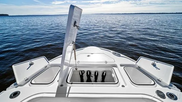 Slide: The Image of 2025 Blackfin 262 HB boat with open storage compartments on calm water. - 4