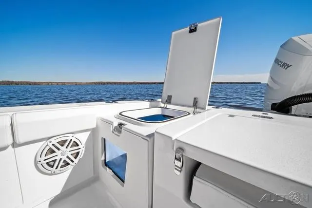 Slide: The Image of 2025 Blackfin 262 HB boat interior with open storage compartment, speaker, and Mercury engine. - 7