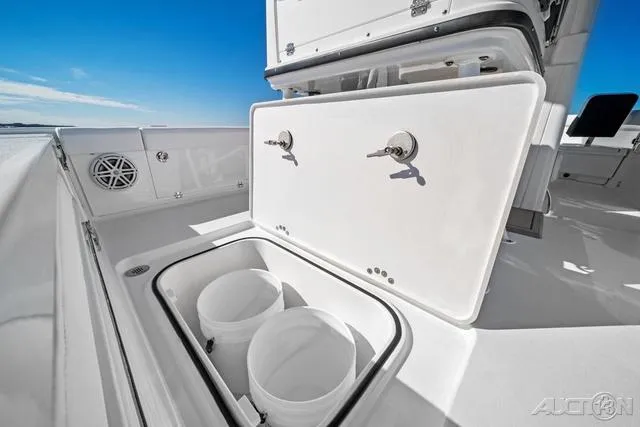 Slide: The Image of 2025 Blackfin 262 HB boat storage compartment with open lid and buckets inside. - 9