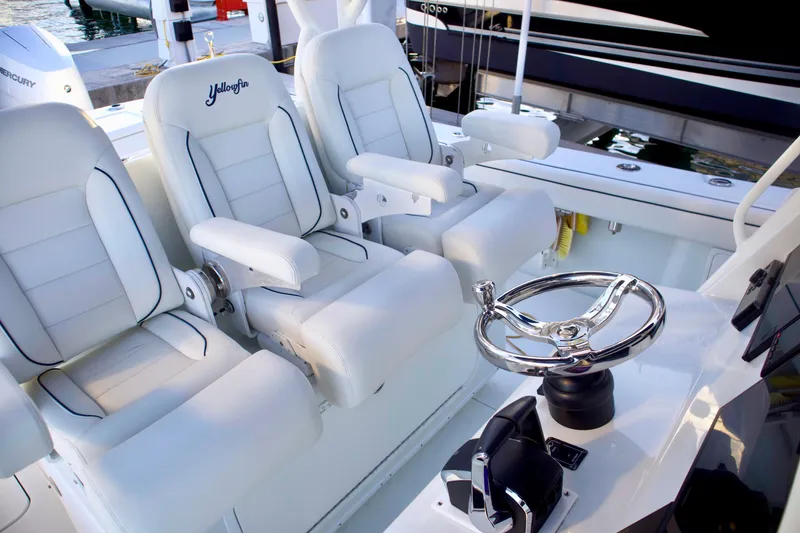 Slide: The Image of 2017 Yellowfin 39 Offshore boat interior with white cushioned seats and steering wheel. - 22